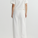 Person wearing a white outfit on a plain background