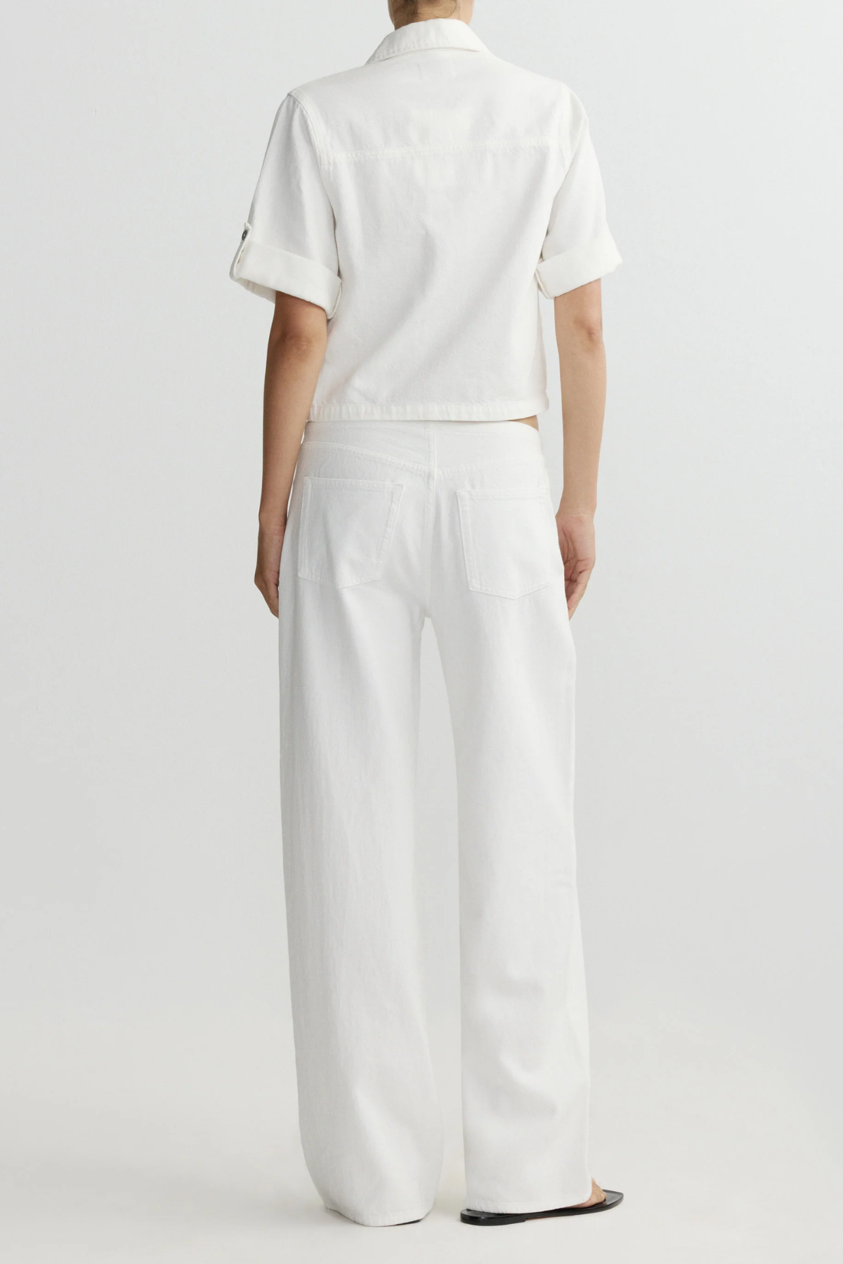 Person wearing a white outfit on a plain background