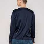 Model wearing a long-sleeve blouse with delicate lace detailing and a flattering tailored silhouette.