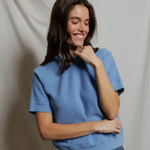 woman in blue top on tan background 
