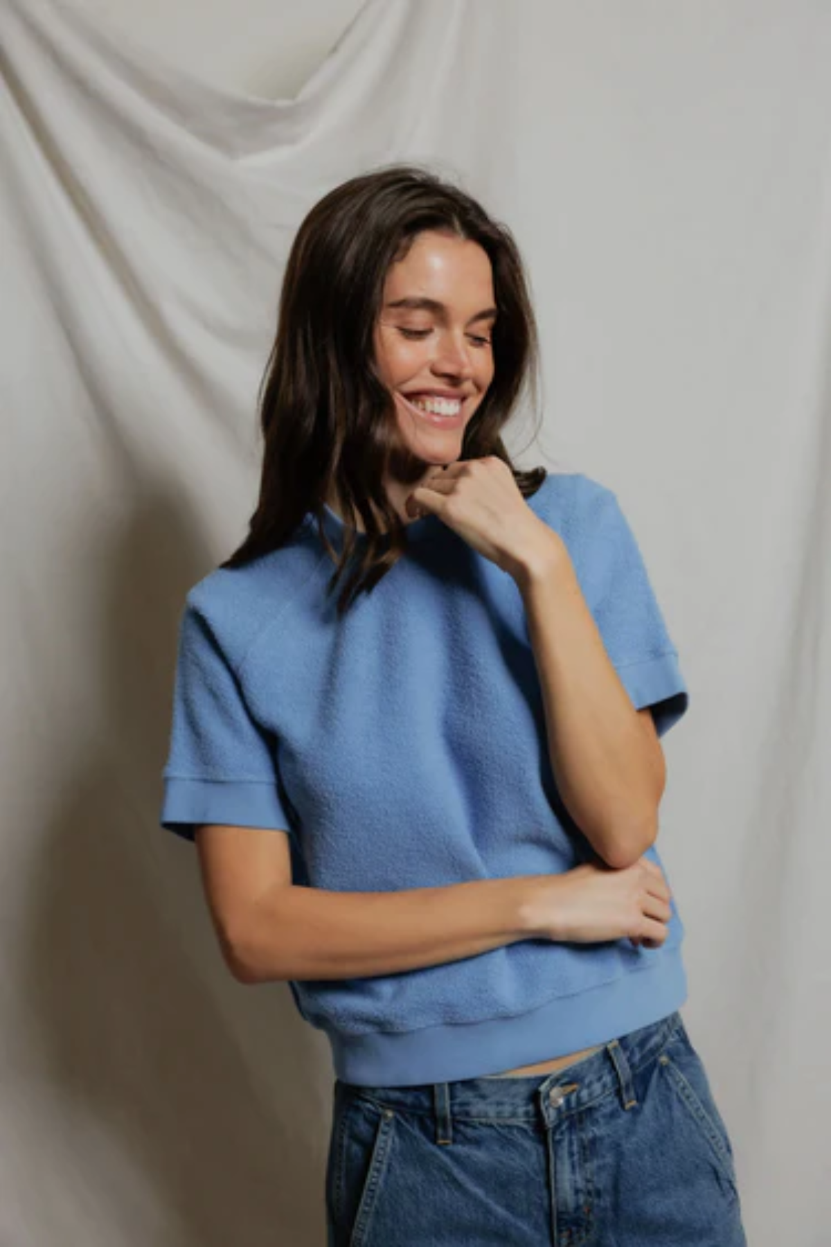 woman in blue top on tan background 
