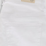 Close-up of the back waistband and pocket area of white denim jeans, showing a beige brand patch with a circular logo.