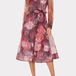 A woman models a sheer long-sleeve midi dress with a floral print in shades of dusty rose, burgundy, and mauve, featuring a tie waist and a collared neckline, set against a plain light gray background.