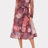 A woman models a sheer long-sleeve midi dress with a floral print in shades of dusty rose, burgundy, and mauve, featuring a tie waist and a collared neckline, set against a plain light gray background.