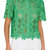 Green lace blouse worn by a person on a white background
