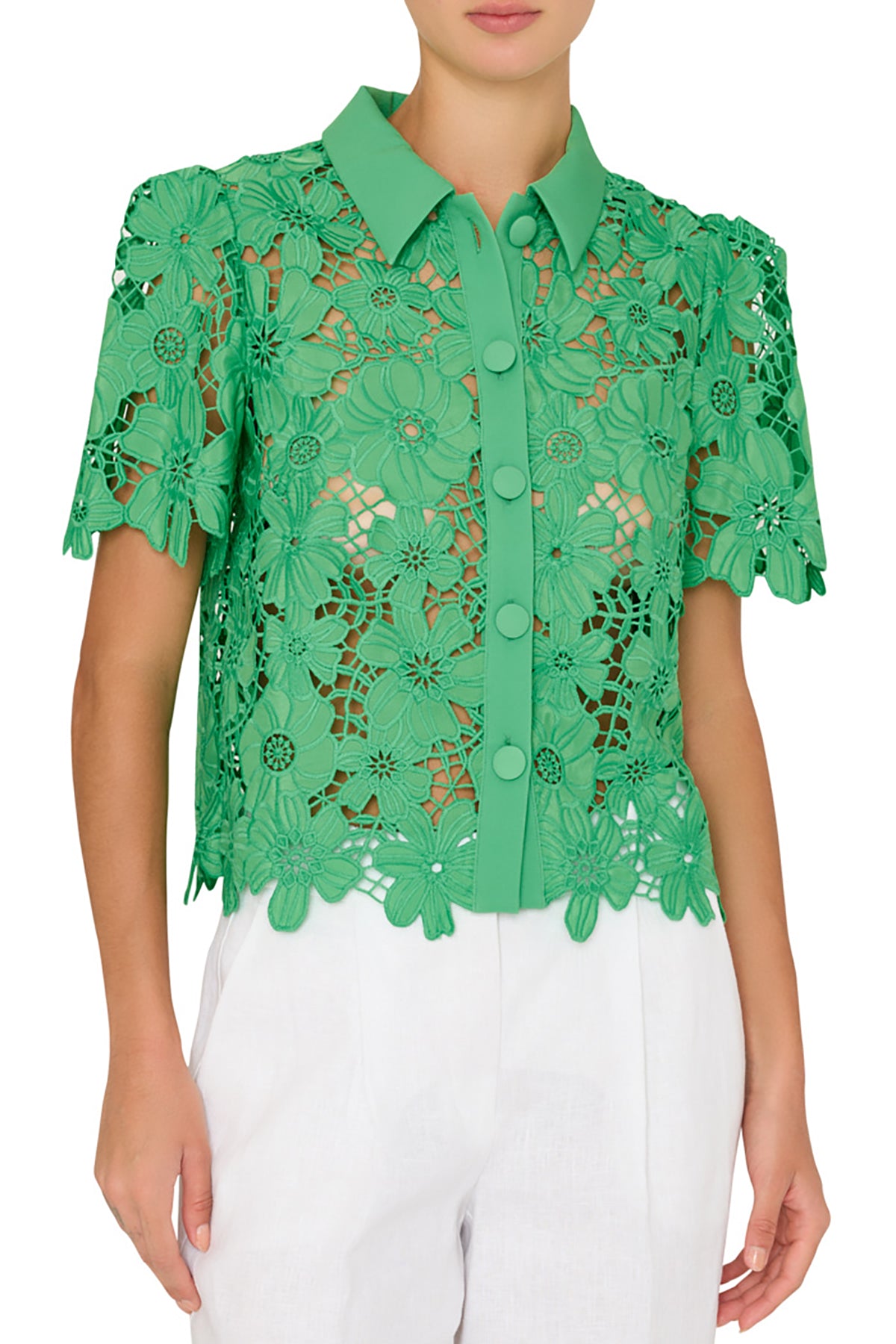 Green lace blouse worn by a person on a white background