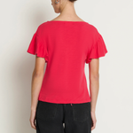 Person wearing a red top and black pants against a white background