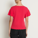 Person wearing a red top and black pants against a white background