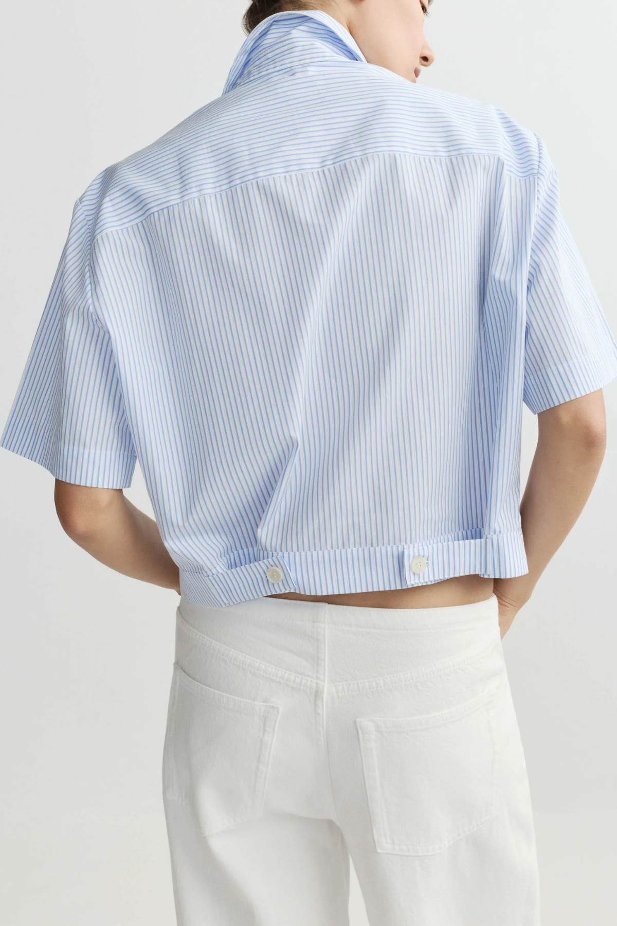 blue striped button up top worn by model against a white background