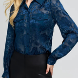 Women's floral burnout blouse featuring long sleeves, a semi-sheer finish, and feminine pattern.