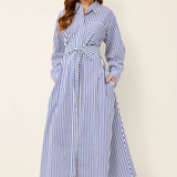 Woman wearing a blue and white striped dress against a plain background