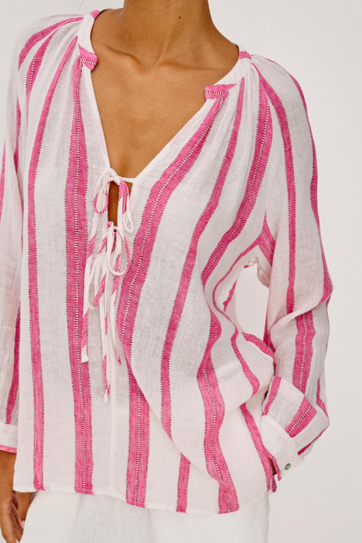 woman in white and pink stripe top on white background 