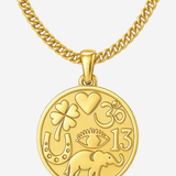 A gold-toned chain necklace with a round medallion pendant featuring embossed symbols and the number 13, shown on a light gray background.