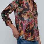 Person wearing l'agence  patterned shirt and jeans on a gray background