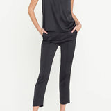 Woman wearing a black sleeveless top and pants on a white background