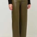 A person wearing olive green wide-leg faux leather pants, styled with a black long-sleeve top and brown leather ankle boots, against a light gray studio background.