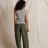 Person wearing a striped tank top and green cargo pants against a plain background