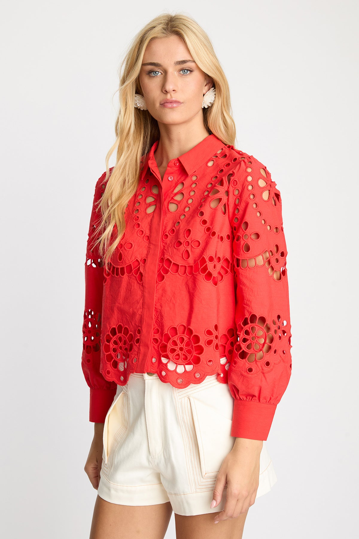 Woman wearing a red lace-up blouse with a white background