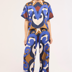 Model wearing a colorful patterned outfit on a white background