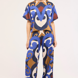 Model wearing a colorful patterned outfit on a white background