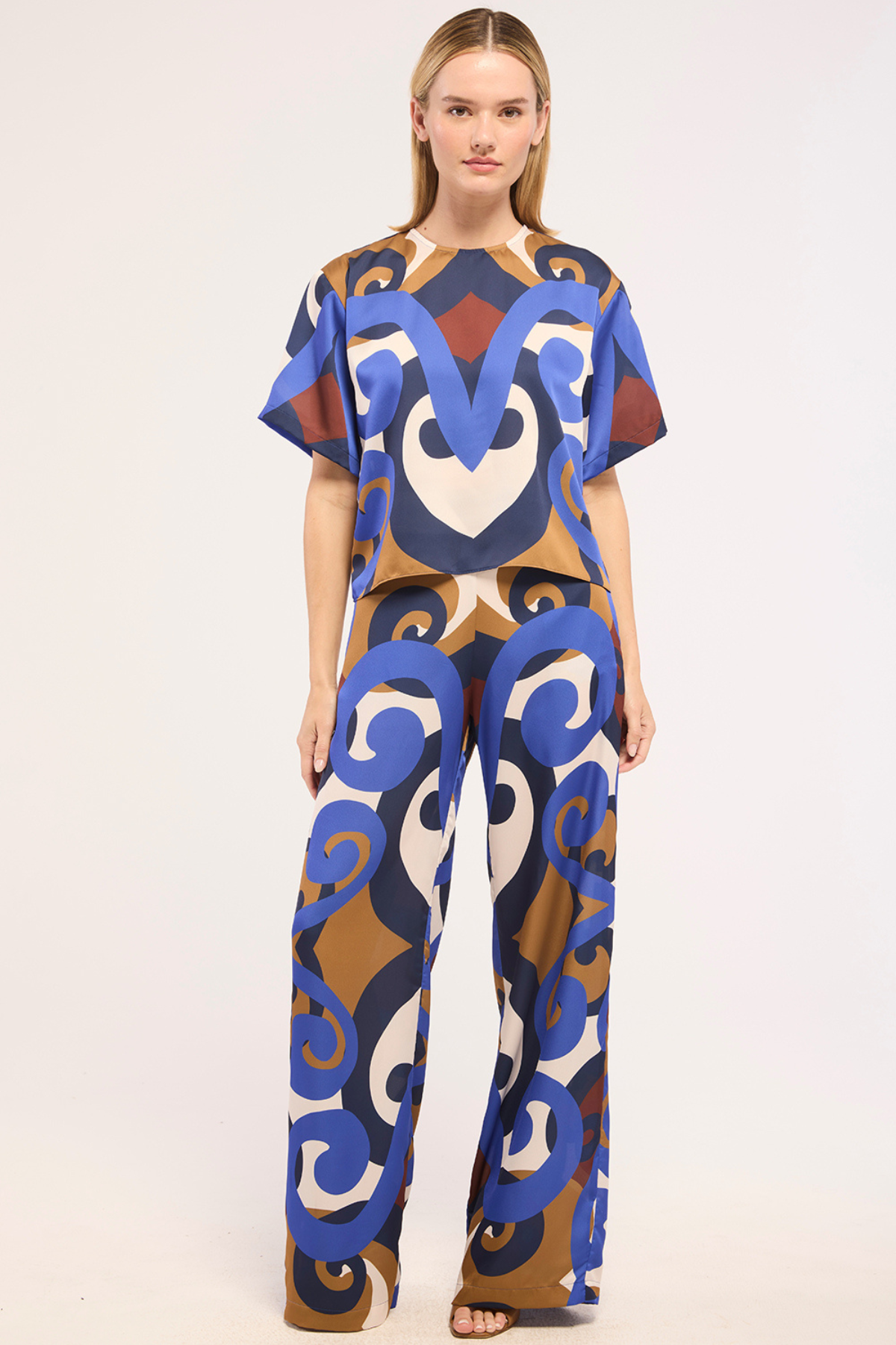 Model wearing a colorful patterned outfit on a white background