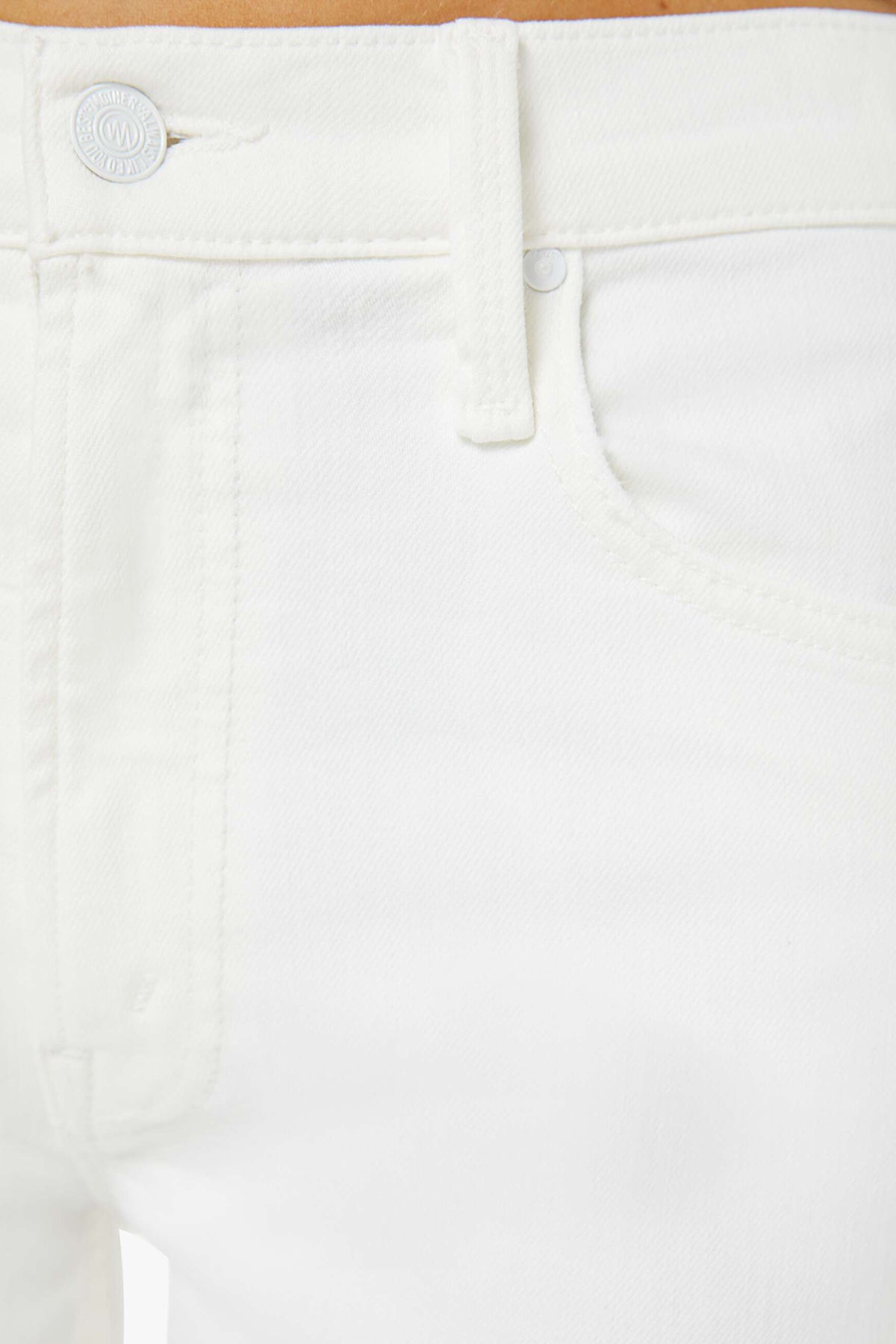 Close-up of white pants with a button on a light brown background