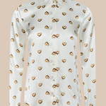 White blouse with gold heart patterns on a beige background