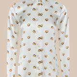 White blouse with gold heart patterns on a beige background