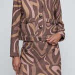 Model wearing a cropped printed jacket featuring a textured neutral-toned pattern with a modern tailored silhouette.