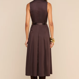 A woman shown from the back wearing a sleeveless dark brown midi dress with a matching belt, paired with dark brown boots, against a solid beige studio background.