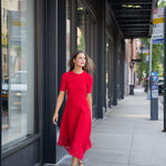Elegant red dress with a fluid silhouette, styled for an evening setting.
