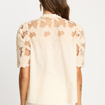 Woman wearing a beige lace blouse on a white background