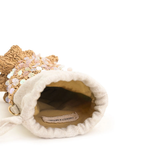 Small decorative bag with a textured surface and visible brand label on a white background