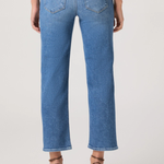 Person wearing blue jeans on a plain background