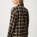 Woman wearing black and gold patterned top against a white background