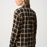 Woman wearing black and gold patterned top against a white background