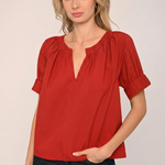 Woman wearing a red blouse with a plain background