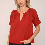 Woman wearing a red blouse with a plain background
