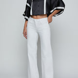 Person wearing a black and white outfit with wide-leg pants on a plain background