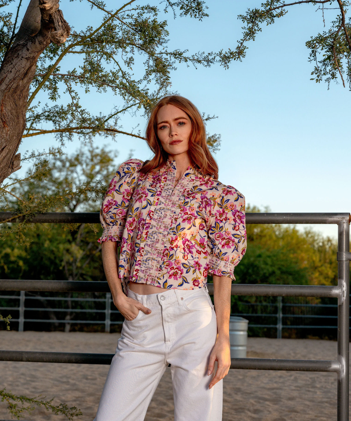 woman in printed blouse outside under a tree 