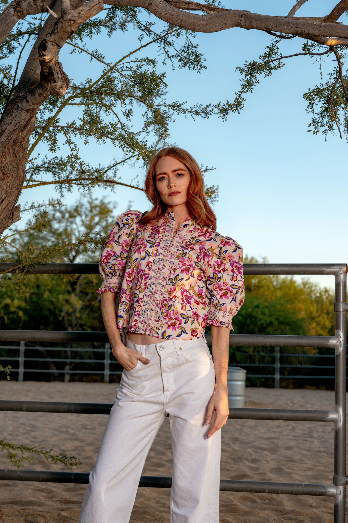 woman in printed blouse outside under a tree 