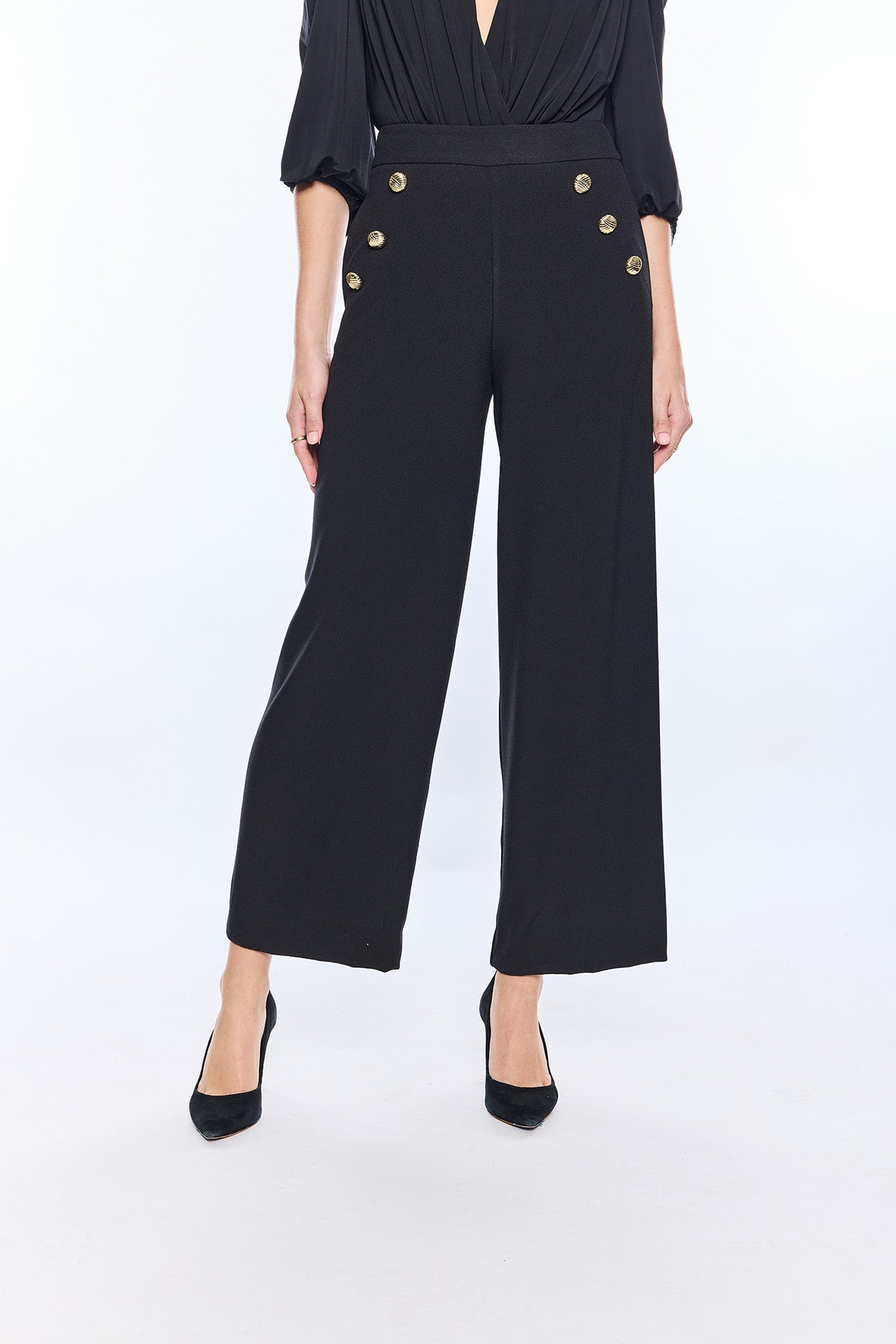 woman in black wide leg pants with gold buttons 