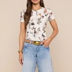 Woman wearing a floral top and denim shorts on a beige background