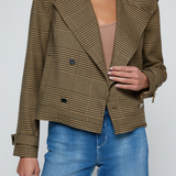 Model wearing a printed trench jacket with jeans on an off white background.