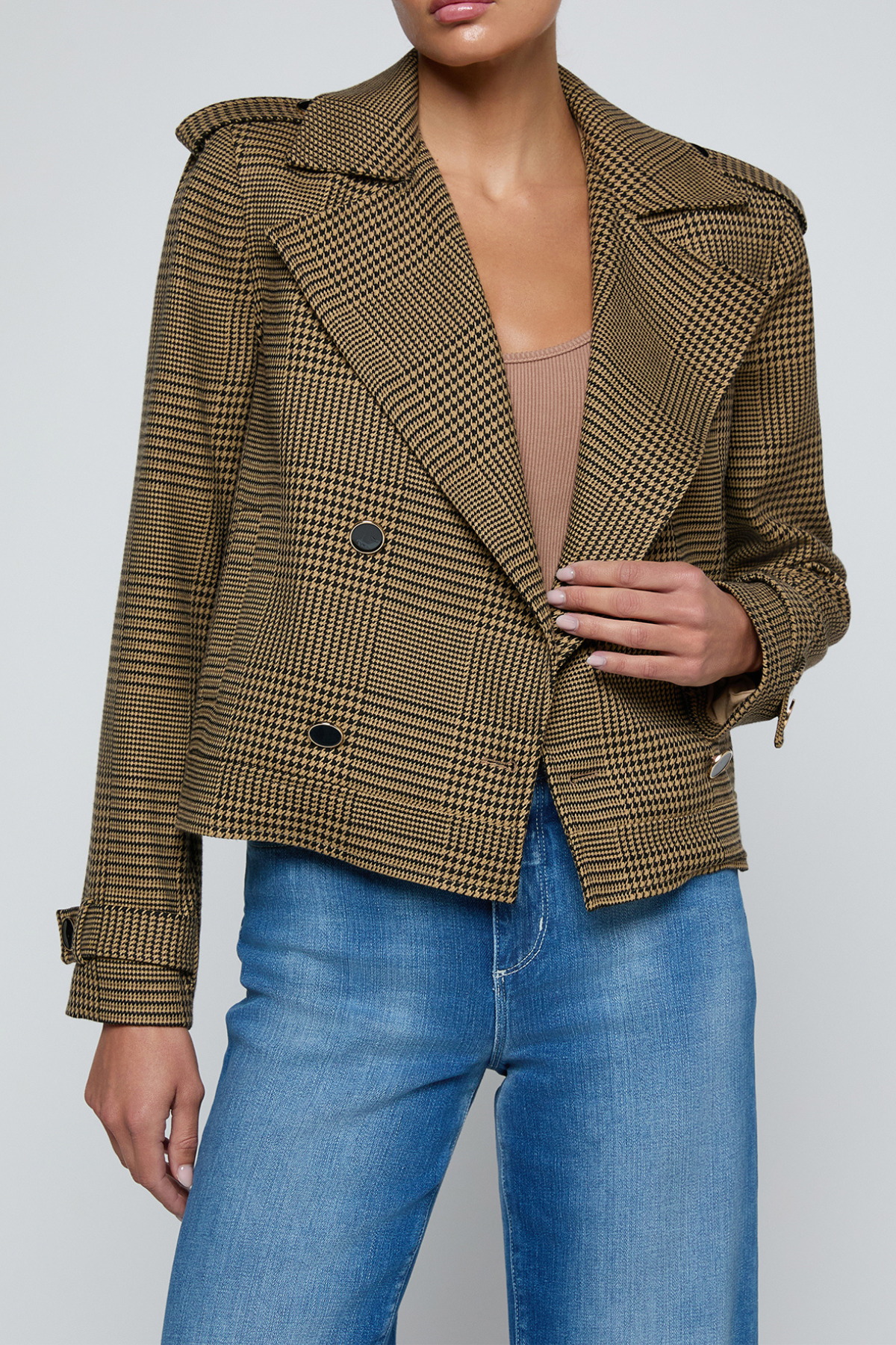 Model wearing a printed trench jacket with jeans on an off white background.
