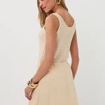 Woman wearing a beige sleeveless top and skirt set on a white background