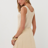 Woman wearing a beige sleeveless top and skirt set on a white background
