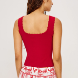 Woman wearing a red sleeveless top with a white background