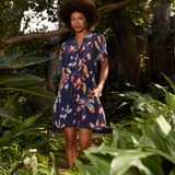 Woman in a floral dress standing among green plants