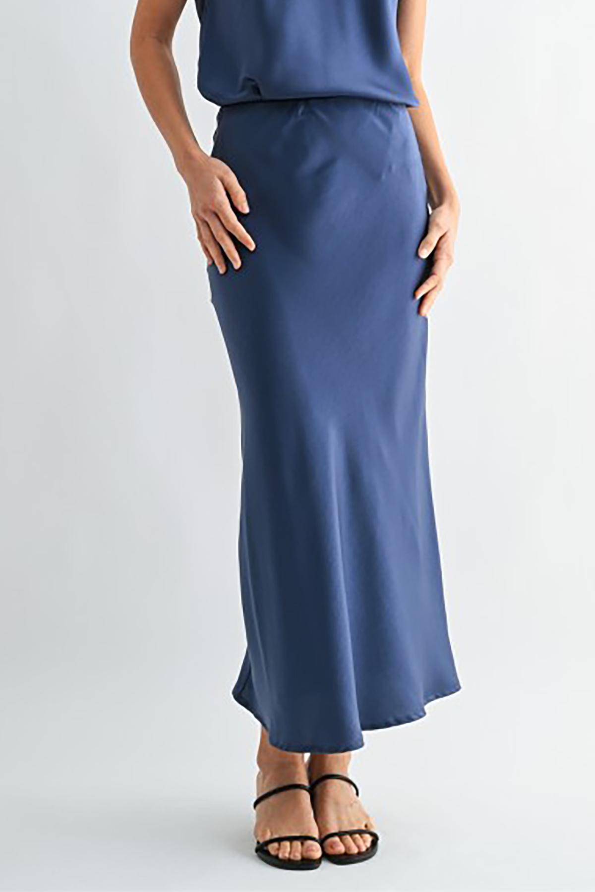 Person wearing a blue skirt on a light gray background